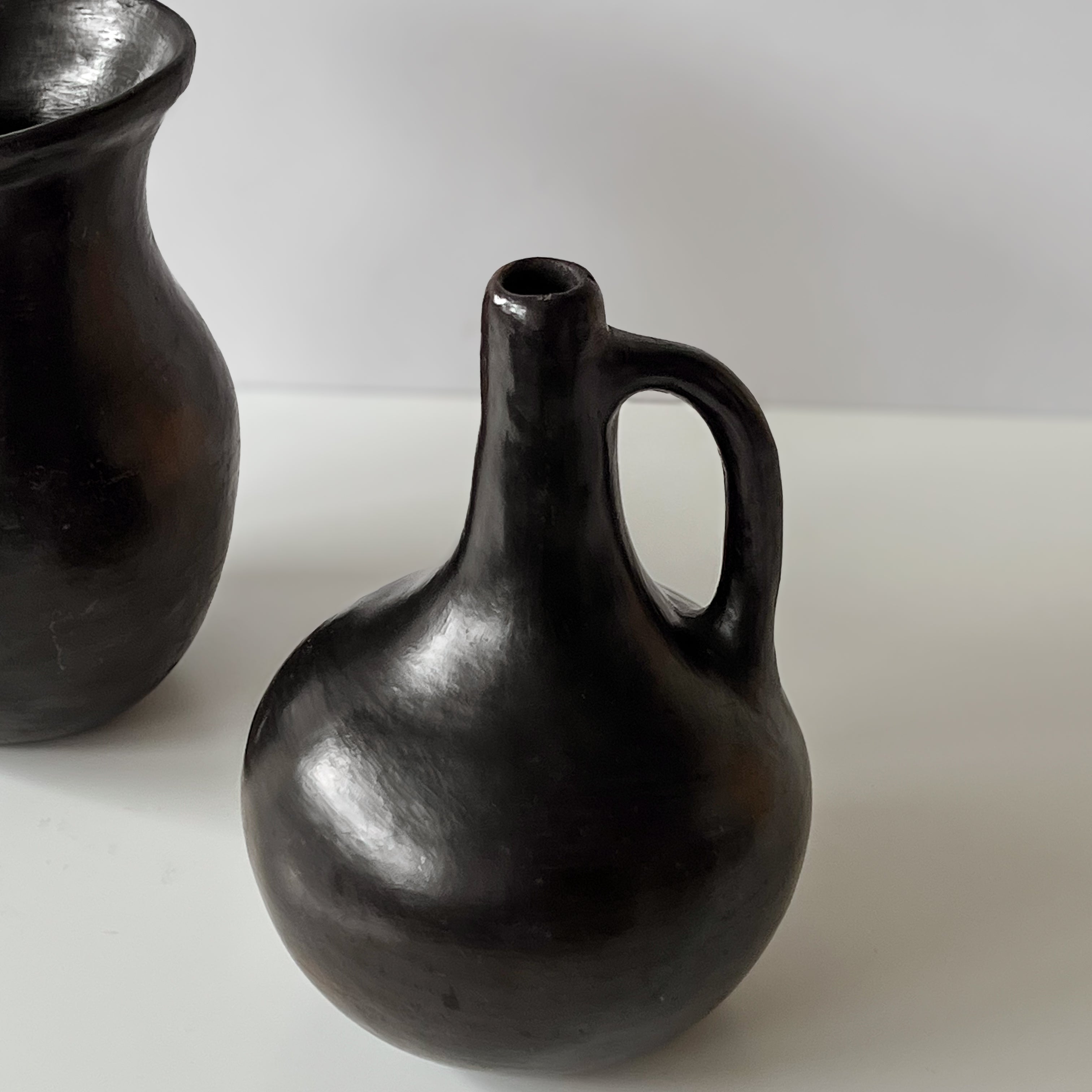 set van twee zwarte aardewerken vazen met handvat – pre-loved Noii HOME
